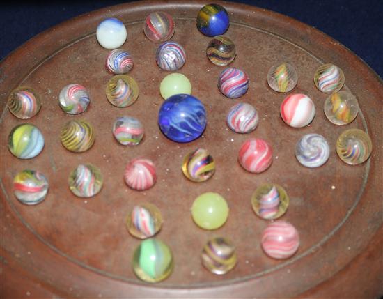 A solitaire board with 19th Century glass marbles